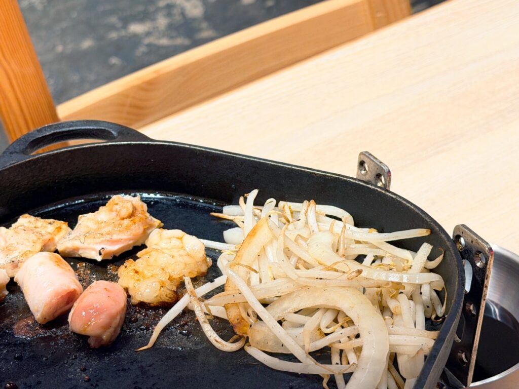 鉄板で焼いているホルモンと焼き野菜
