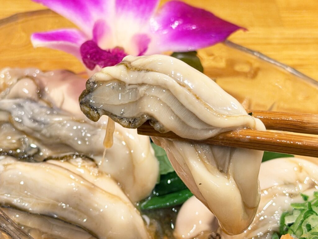 生牡蠣ポン酢の牡蠣を箸で持ち上げた様子